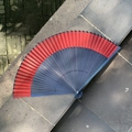 Elegant red and black gradient folding fan with bamboo frame on stone stairs - Plain Blue Red