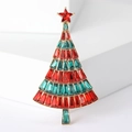Detailed view of a sparkling Christmas tree brooch with colorful rhinestones on a white stand - Green+Red