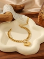 Detailed macro of gold-plated chain bracelet with heart charm on white ceramic tray - Heart Bracelet (ZHB1053 Gold)