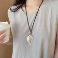Detail showing two-tone leaf pendant with silver and gold finish on a black cord - 86# Two-Tone Leaf Pendant