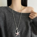 Gros plan d'un collier pendentif étoile de mer argenté texturé porté par un mannequin - Type F Collier Pendentif Étoile de Mer Argentée Porte-clés