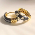 Gold hoop earrings with black enamel finish and white floral pattern accents - Black