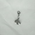 Detail of silver stainless steel shell pendant with lobster clasp on fabric texture - Clam