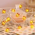 Close-up of warm yellow Christmas gift box LED string lights in a cozy home setting - 1m 10-LED (2AA Battery Model) / Yellow Gift Box