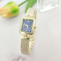 Macro shot of luxury rectangular gold watch with diamonds and deep blue dial face - Gold Blue