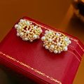 Macro shot of cluster pearl earrings with gold base on a textured red jewelry box - Gold Pearl Geometric Ear Buckle