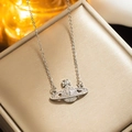 Silver Saturn pendant necklace with clear crystals on a beige luxury jewelry cushion - 8823 Steel-colored Saturn