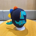 Detail view of navy blue knitted kids hat featuring colorful dinosaur 3D spikes and patterns - Dinosaur Tail Single Hat - Navy
