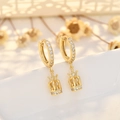 Elegante gouden kroon oorringen met witte kristallen op wit keramiek - Goud