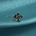Macro detail of silver flower nose stud with black cubic zirconia on teal satin fabric - Style A / Black Zirconia