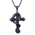 Detalle del colgante de cruz con calavera negra y textura de serpiente sobre metal - Estilo Negro