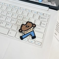 Macro detail of cartoon cookie embroidery patch with PHOTO text on a laptop keyboard - Brown Bear