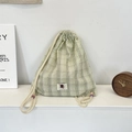 Detail eines grün-weiß karierten Kordelzug-Rucksacks aus Canvas mit Stoffstruktur - Fruchtgrün
