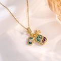 Macro view of gold camera, airplane, and purple suitcase pendants on silk background - Gold Airplane Camera Style B