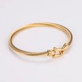 Détail du bracelet câble fer à cheval doré avec design en corde torsadée sur fond blanc - Or sans breloque clé