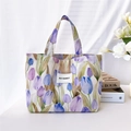 Nahaufnahme der Canvas-Handtasche mit Tulpenmuster und May Rabbit-Label auf Stoff - Lila Tulpe