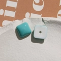 Close-up of square resin beads in turquoise and white with center holes for DIY crafts - Dark Green Square