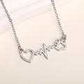 Detailed close-up of a silver heartbeat necklace with heart and paw print pendant charms - Silver