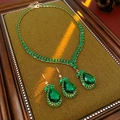 Gros plan d'un collier avec pendentif goutte émeraude et boucles d'oreilles assorties - Ensemble Vert de 2 Pièces
