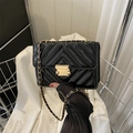 Detail of black patent leather crossbody bag with V-shaped quilting and gold chain strap - Black