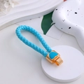 Dettaglio del portachiavi in pelle intrecciata blu con ciondolo a cuore dorato - Cordino in pelle blu lago