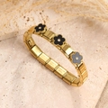 Pulsera elástica de acero dorado con dijes de flores de esmalte sobre travertino - Estilo de Trébol de Cinco Hojas con Concha Negra / Dorado