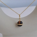 Tiger eye stone necklace on a minimalist display stand with golden chain and round pendant - Gold Necklace (DDK005)