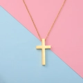Detail of a golden cross pendant necklace on a creative pastel pink and blue background - Gold