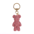 Close-up detail of a pink rhinestone bear doll keychain with a shiny golden metal ring clasp - Pink