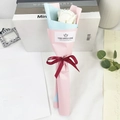 Close-up of a single white soap rose bouquet wrapped in pastel paper with ribbon - White Rose