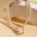 Detail der dreilagige Perlenkette mit Strass-Blumenanhänger auf skulpturalem Gipsständer - Halskette-Weiß