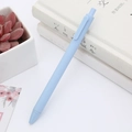 Minimalist light blue retractable gel pen with matte finish on white book background - Morandi Macaron Blue