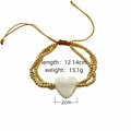 Detalle de pulsera artesanal de cuentas doradas con corazón blanco y medidas - Pulsera con colgante de corazón / Blanco