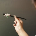 Classic black wooden hair pin featuring white flower, pearl, and green leaf detail - Peach Blossom Hair Stick