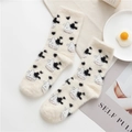 Calze bianche di peluche con motivi di mucca in bianco e nero su sfondo piatto - Taglia unica / Mucca Bianca