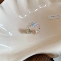 Dettaglio anello a fiori smaltati con perle su un vassoio decorativo a conchiglia - Stile Fiore Colorato (Anello-Argento-Colorato)