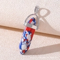 Macro shot of tricolor hexagonal stone pendant with silver metal bail on beige surface - Blue Red Veined Stone