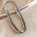Dettaglio di una collana di perle a doppio strato bianche e grigie su seta - Collana di Perle a Doppio Strato Bianca e Grigia con Chiusura in Metallo Argentato (Stile 13)