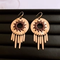 Close-up of golden hollow metal earrings with brown woven rope and long tassel details - Earrings-Gold-Coffee