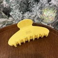 Detail of yellow acetate hair claw clip with Barrette La France text on a wooden tray - Milk Yellow - Round Head 8-Tooth