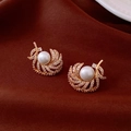 Dettaglio di orecchini a piuma dorata con perla bianca centrale e strass scintillanti - Perno in Argento S925 / Placcato Oro 18K / Oro