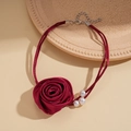 Dettaglio del choker rosa in raso bordeaux con perle bianche e catena di estensione - Rosso