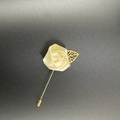 Detail of handmade cream satin rose lapel pin with a gold leaf on a long suit needle - Lotus Pink