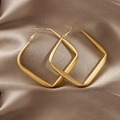 Close-up of matte golden square hoop earrings placed on a champagne silk background - Gold Matte Square Hoop (E031)