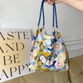 Handheld floral canvas tote bag featuring colorful flower patterns and blue rope handles - Monet Garden Blue Yellow