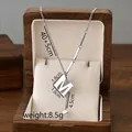 Silver titanium steel necklace with M letter pendant and tassel on jewelry cushion - M / Silver