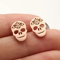 Macro shot of rose gold skeleton stud earrings with intricate cutout floral patterns - Rose Gold