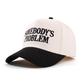 Detail of embroidered 'SOMEBODY'S PROBLEM' text on contrast cotton baseball cap - Beige/Black
