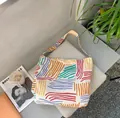 Canvas tote bag with colorful striped pattern and wide shoulder strap on grey mat - Double Layer Single Strap Bag