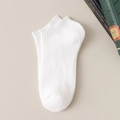 Chaussettes en coton blanc pliées sur un fond texturé beige élégant - Taille unique / Blanc